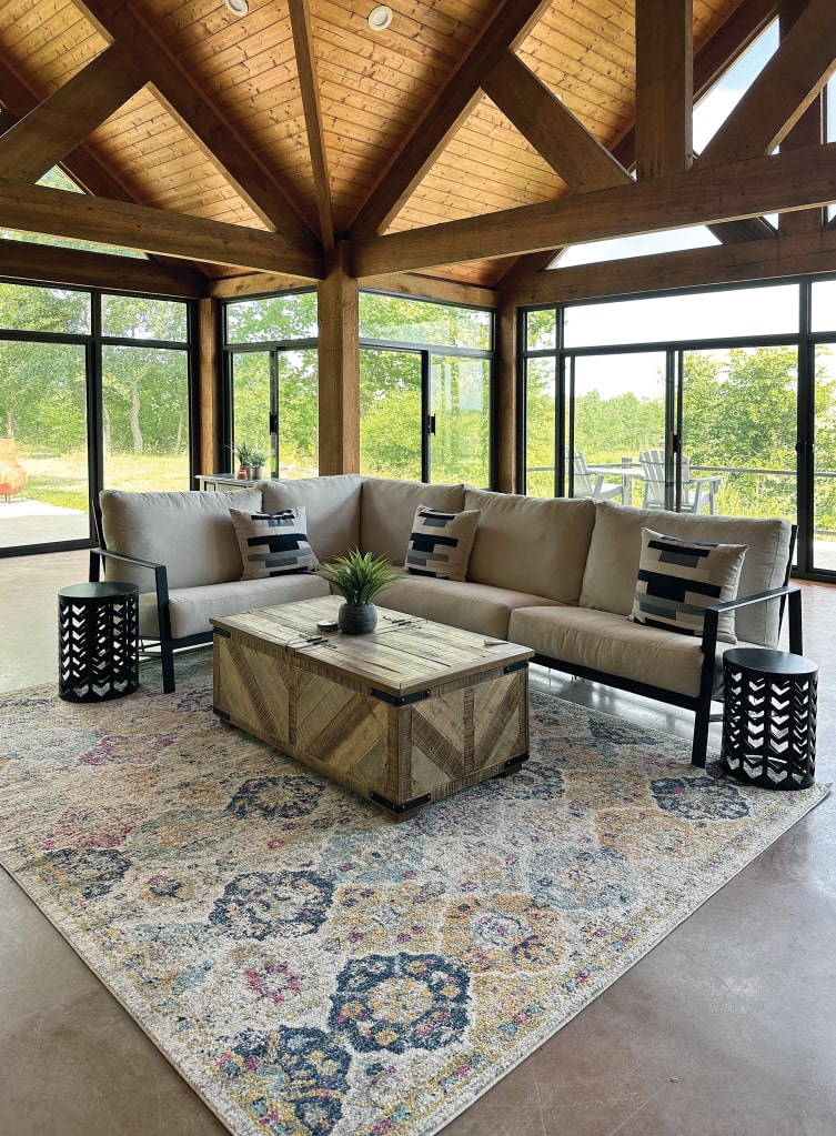 Sunroom interior in San Antonio, TX with floor-to-ceiling windows, vaulted wood ceiling, and cozy modern furniture.