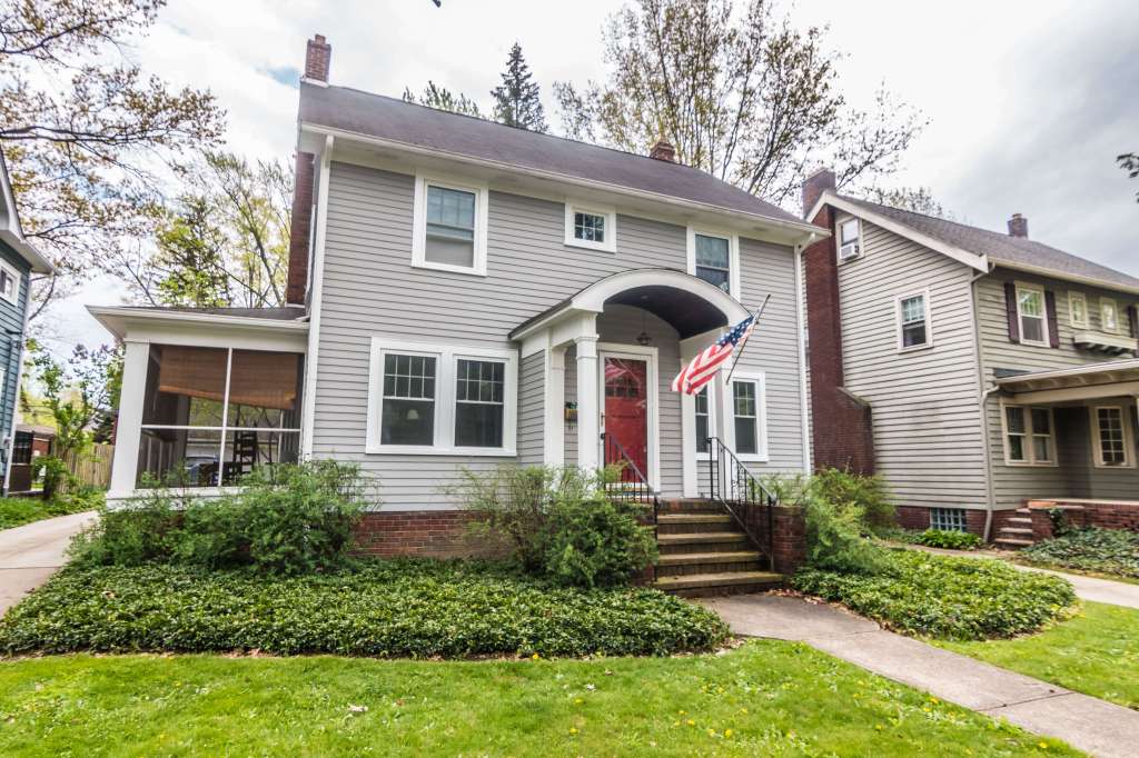 Traditional Omaha home remodel with new siding, energy-efficient windows, a sunroom enclosure, and manicured landscaping